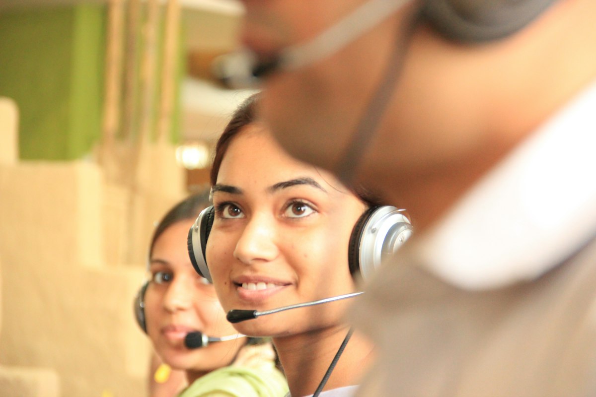 Two customer support agents with headsets practising calls