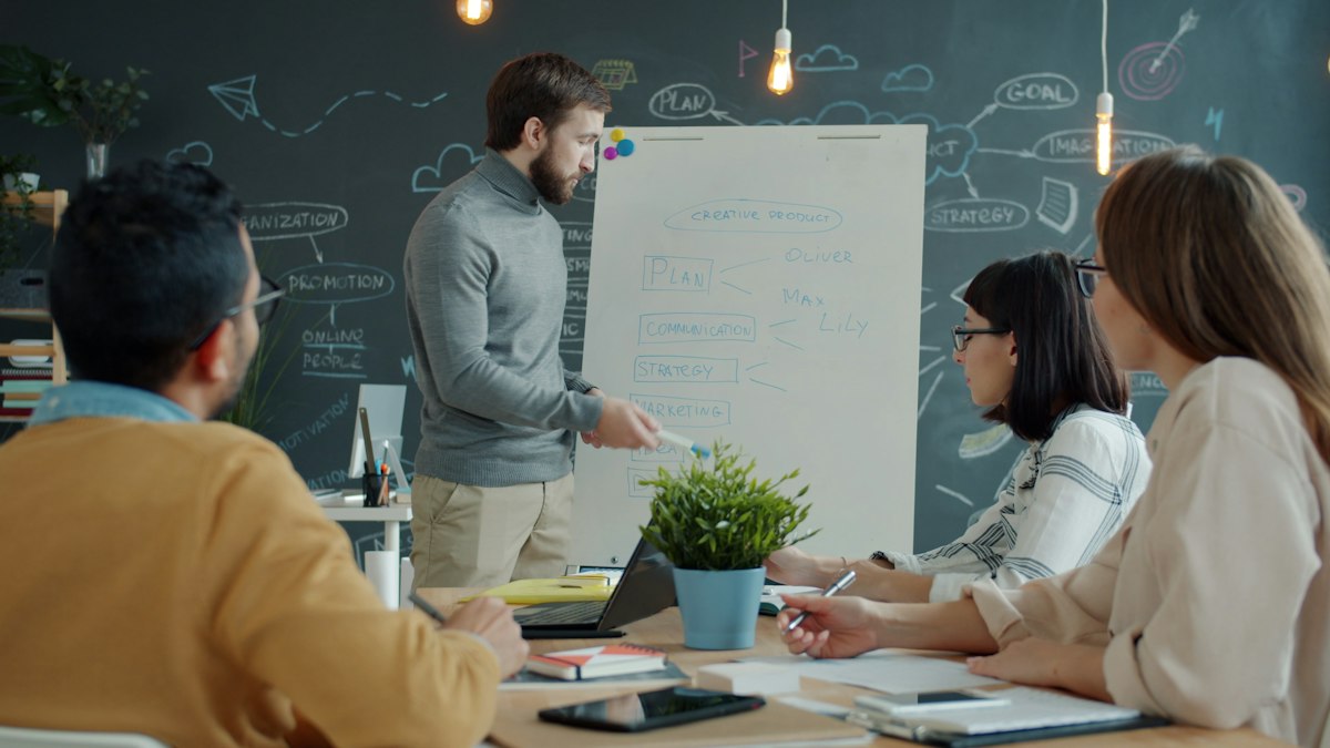 Team collaborating around a whiteboard during a training workshop