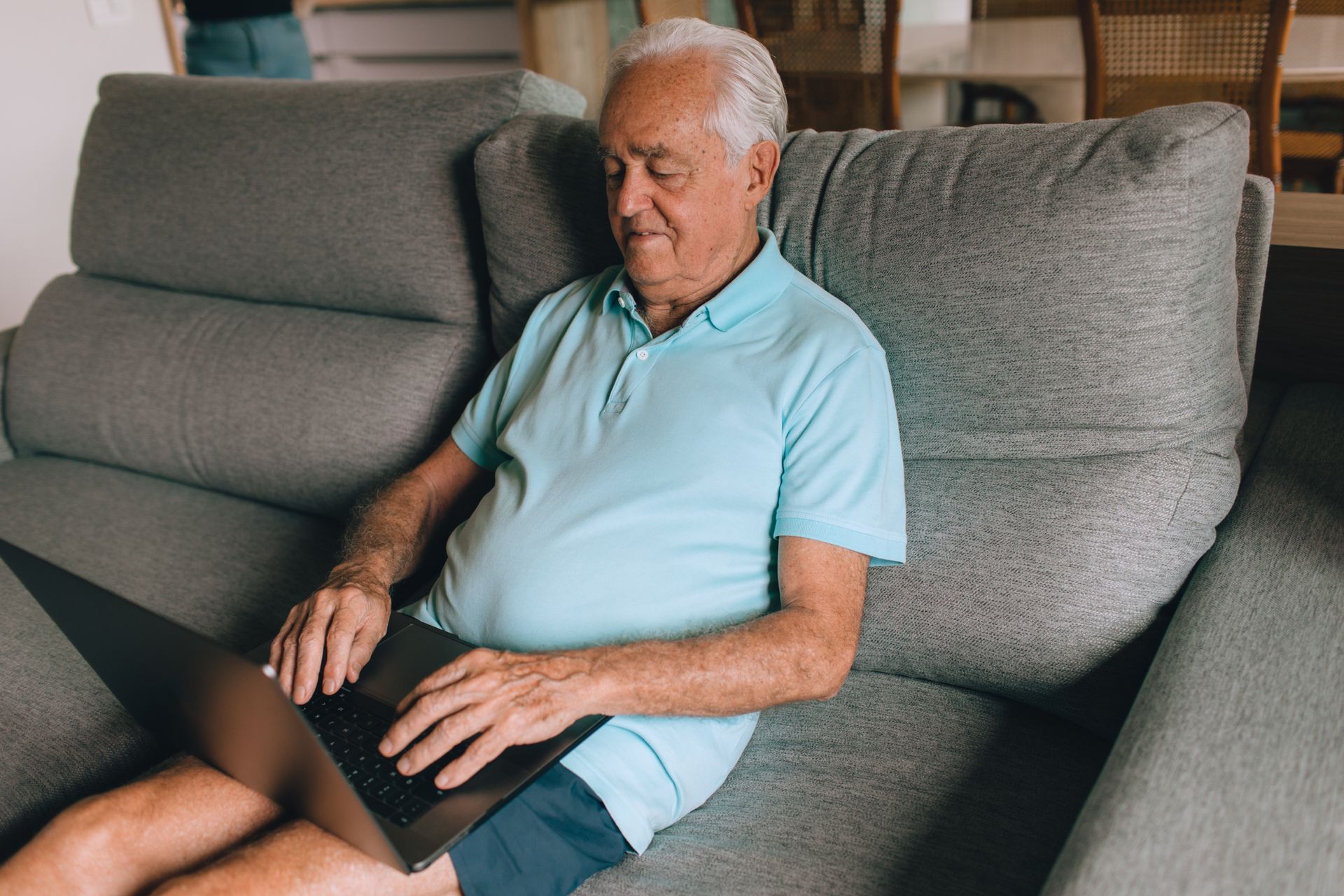 Elderly man using a laptop at home