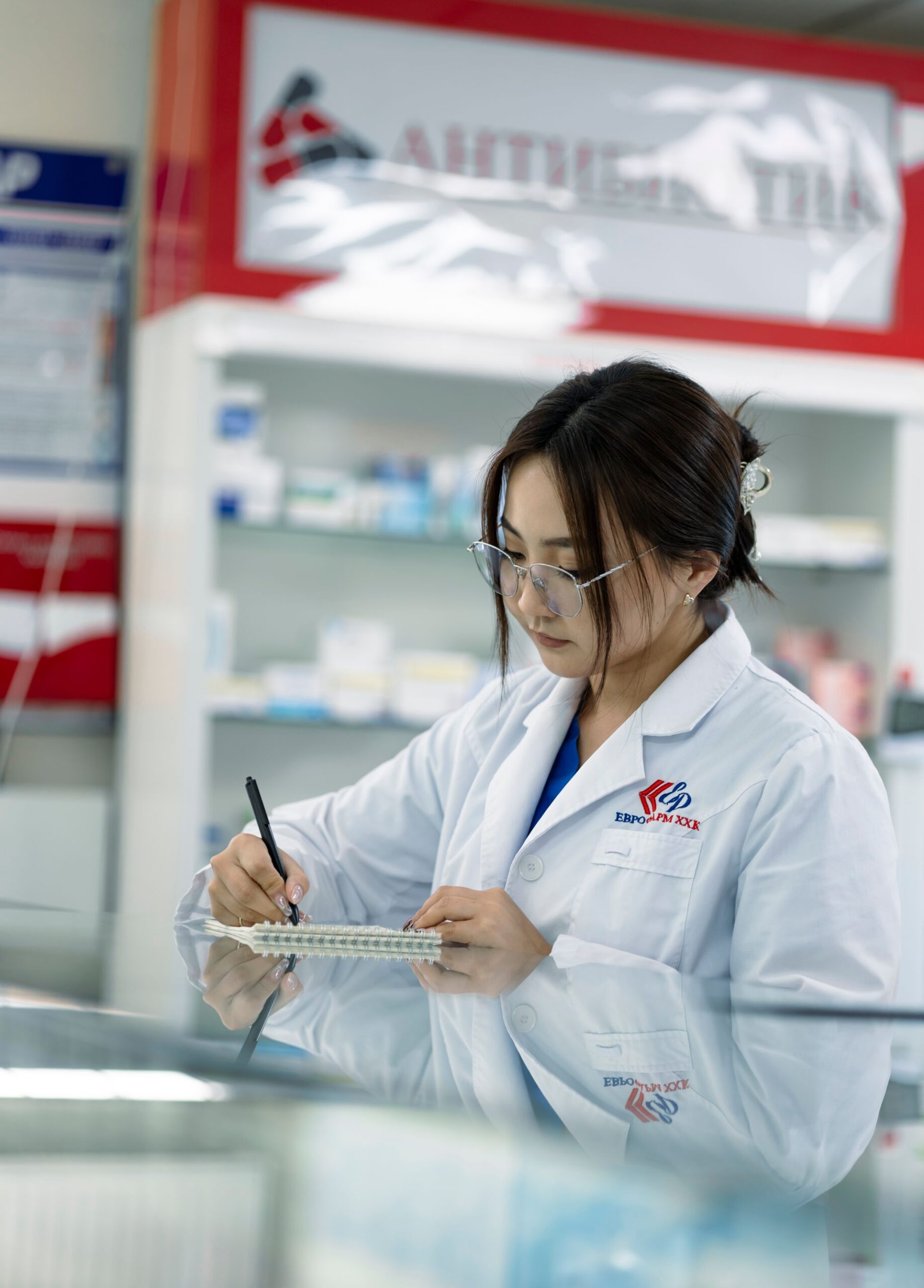 Pharmacist taking notes in a pharmacy