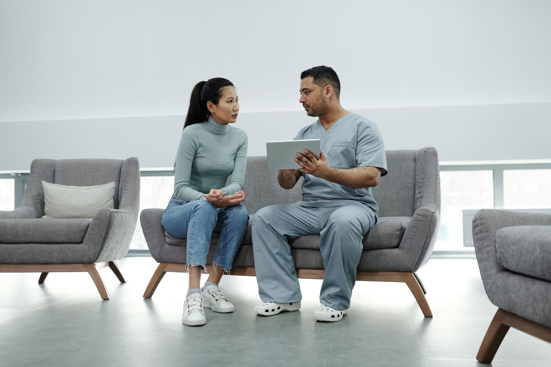 Healthcare provider consulting a patient with a tablet