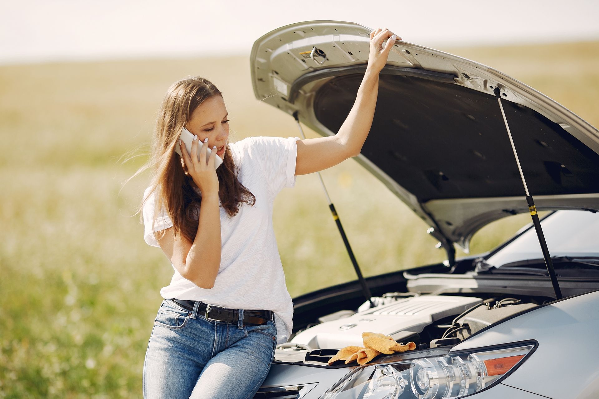 Driver calling for help next to a broken-down car