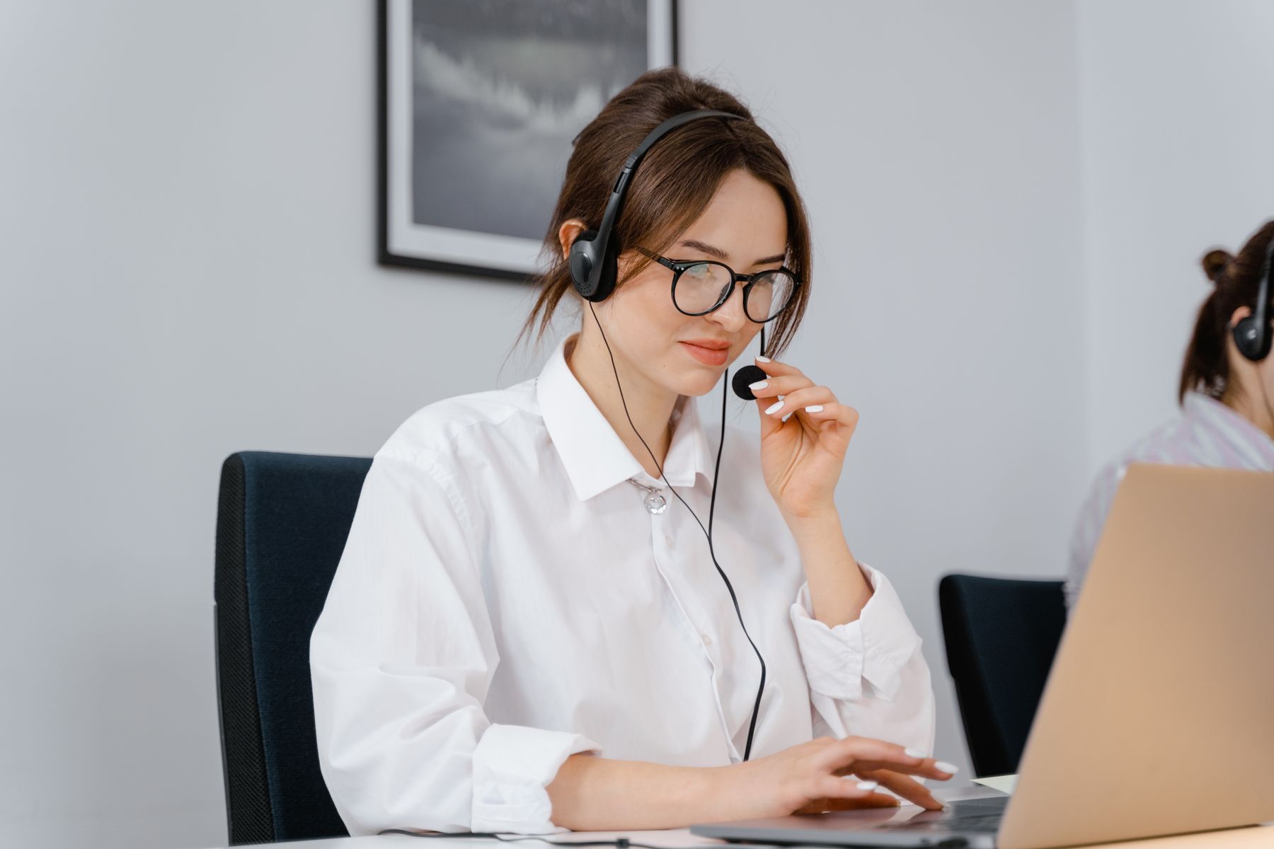 Multilingual customer support agent speaking with a customer through her headset