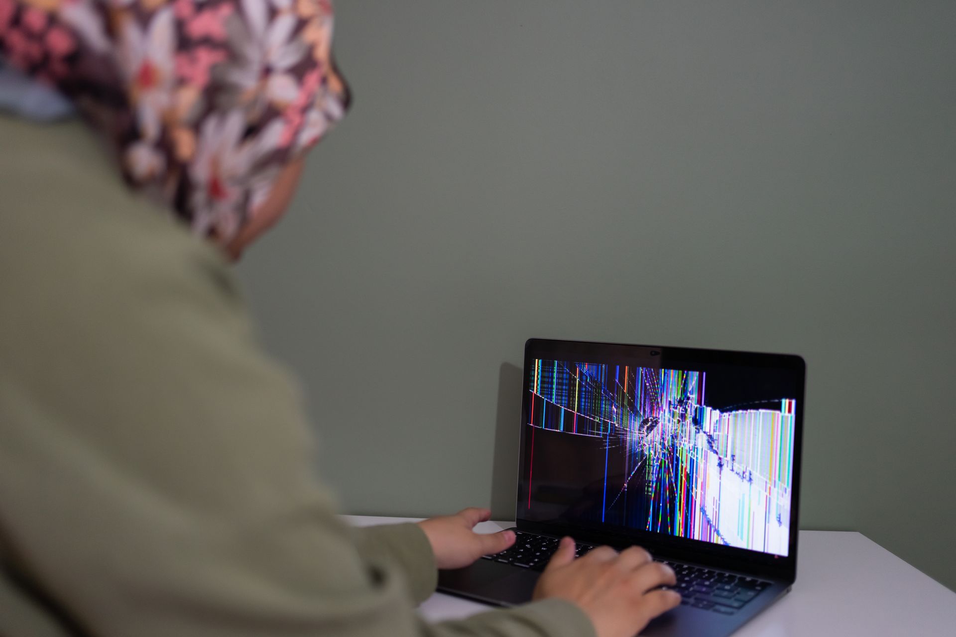 Person using a laptop with a cracked screen
