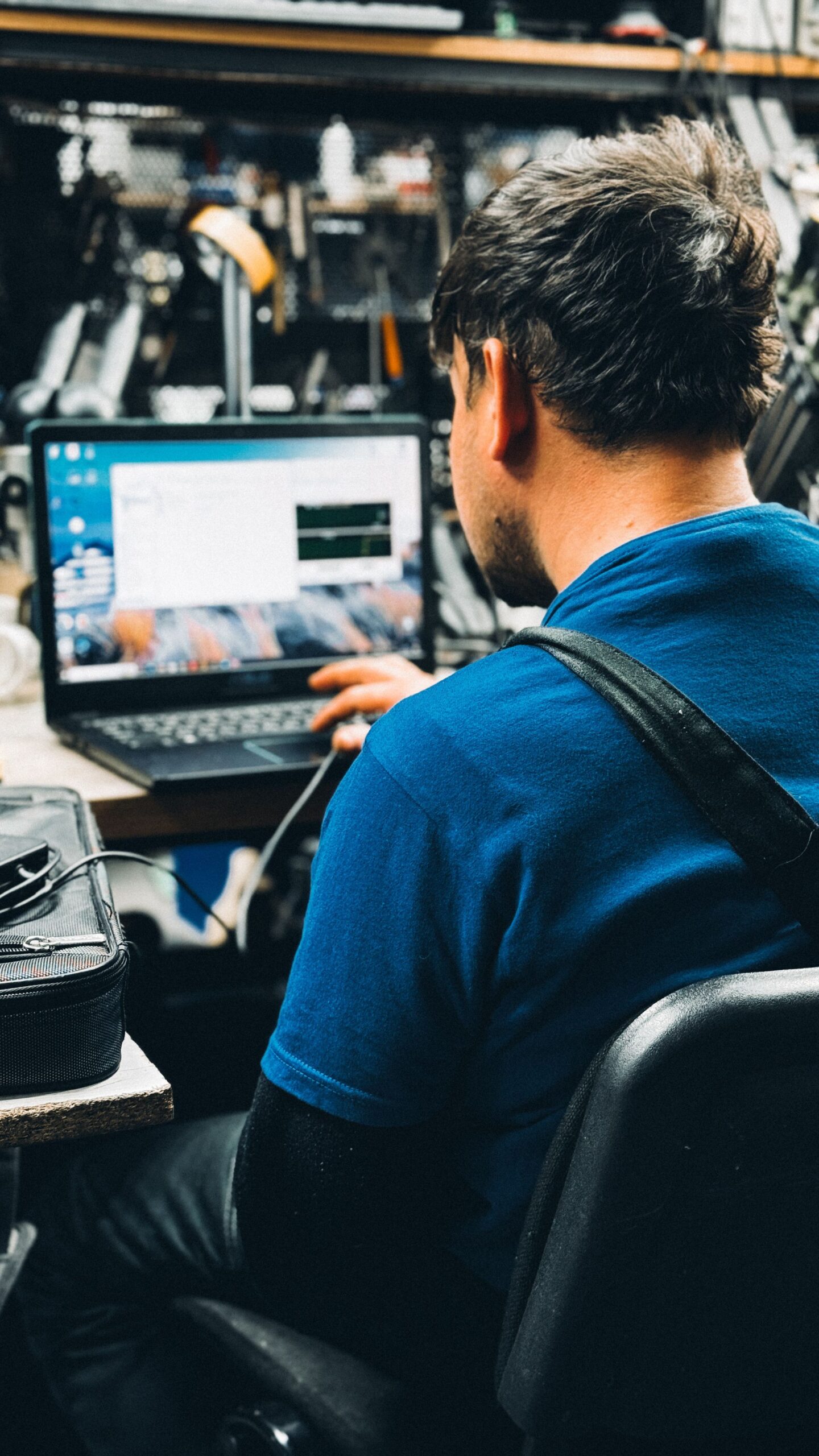 Technician working on a laptop in a workshop